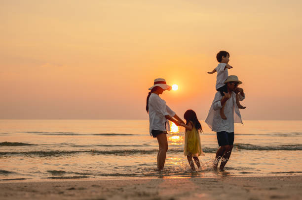 Famille au coucher du soleil, un enfant sur les épaules